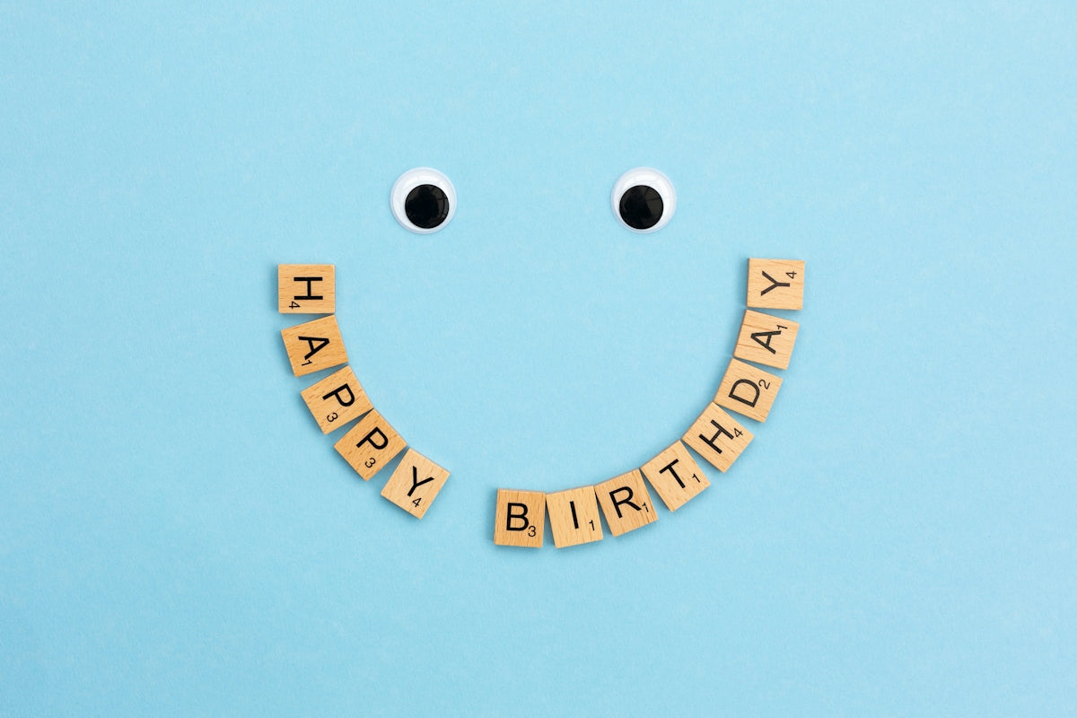 a smiley face made out of scrabbles with the words happy birthday spelled