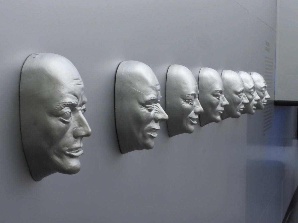 A row of silver faces protruding from a gray wall.