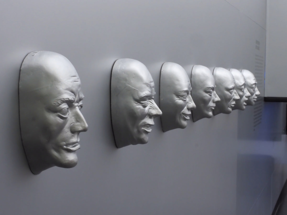 A row of silver faces protruding from a gray wall.