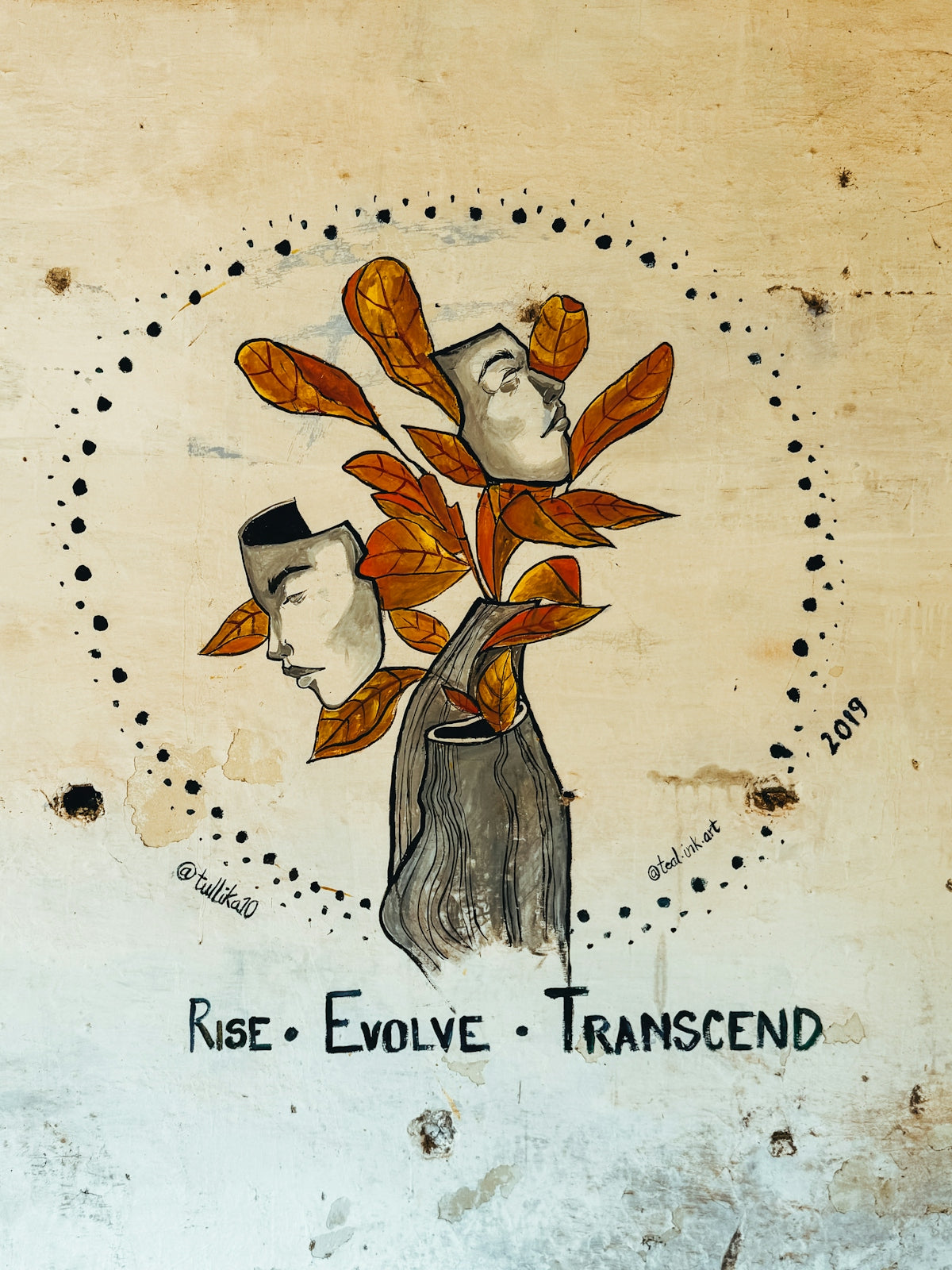 Wall art featuring faces, leaves, and